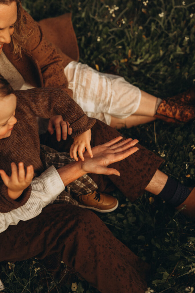 Close-up of a child reaching for their father’s hand during a rainy family photography session in Gympie.