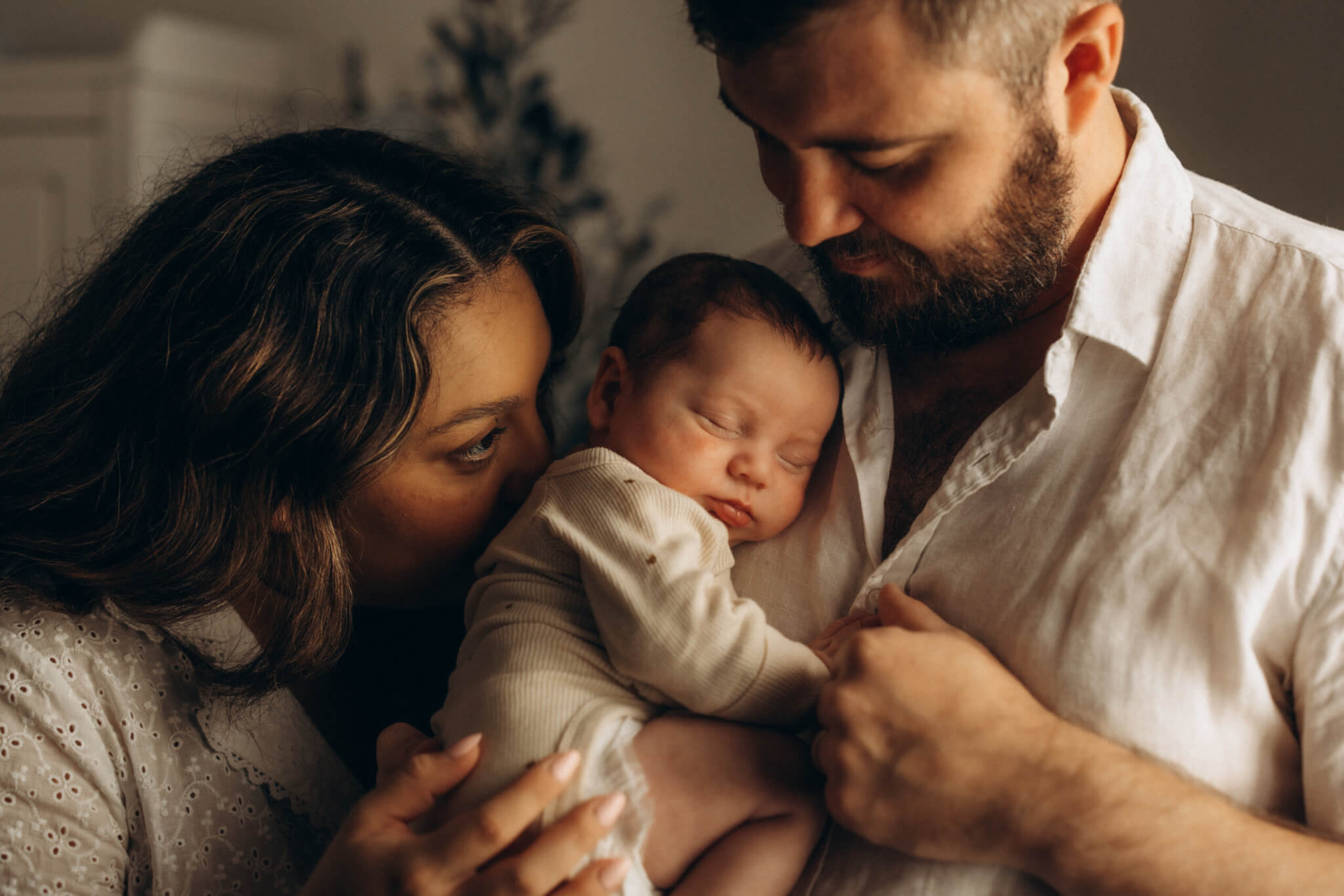 Parents cuddling newborn baby during lifestyle newborn photography session in Gympie